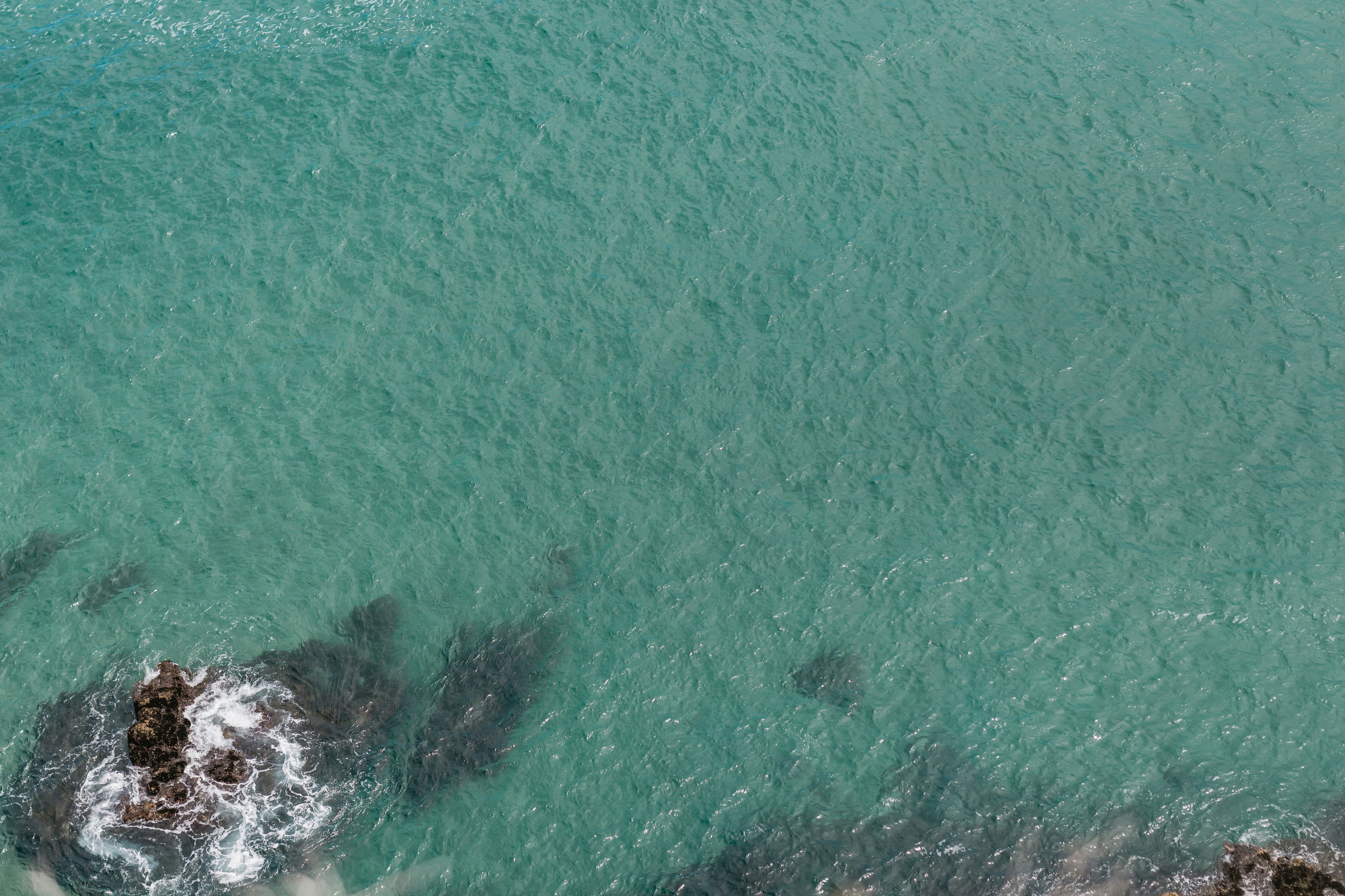 aerial photography of rock formations in the sea